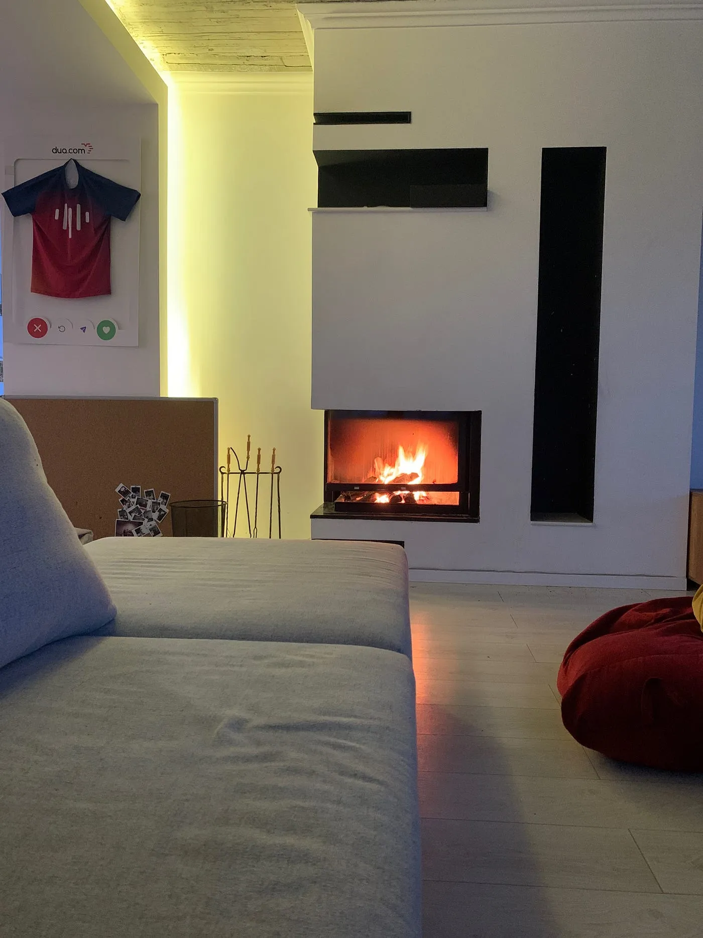 A wood fire burning in a living-room fireplace, warm evening light