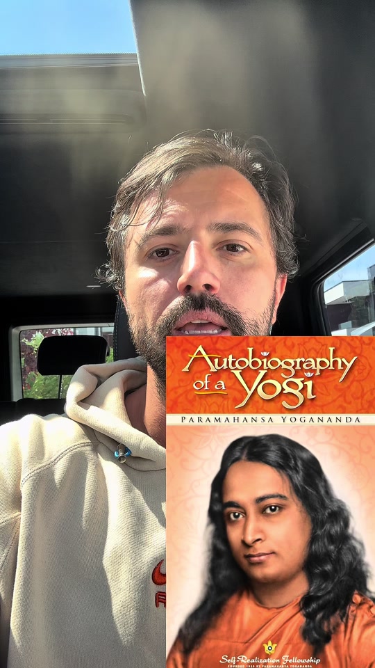 Eduard in a light hoodie inside a car, with the Autobiography of a Yogi cover overlaid in the original video.