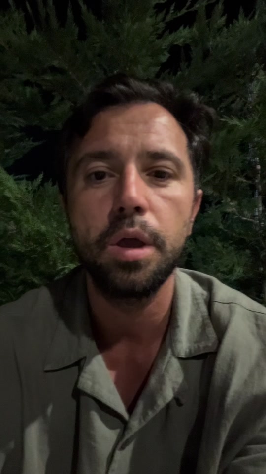Eduard outdoors at night in a green shirt, in the original video about his mother and cancer.