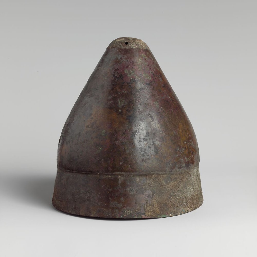 A conical Greek bronze helmet of the pilos type in the Metropolitan Museum of Art collection.