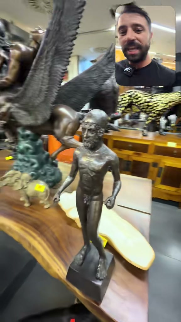The small bearded male figure and its cap in Eduard’s Cologne shop video, with other decorative objects behind it.