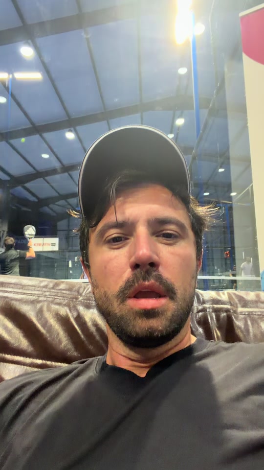 Eduard Luta in a cap, recording his reaction while seated indoors.