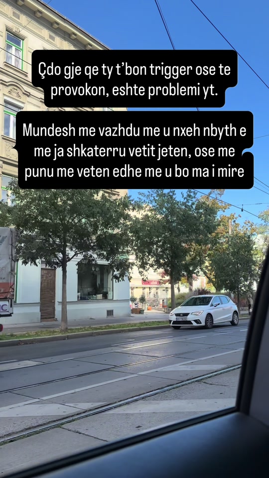 Original video thumbnail of a street seen through a vehicle window, with Albanian text about provocation and working on yourself.