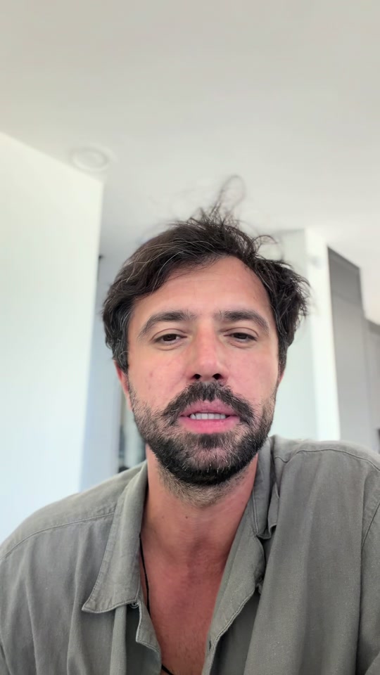 Eduard indoors in a green shirt in the original video about empathy and childhood experiences.