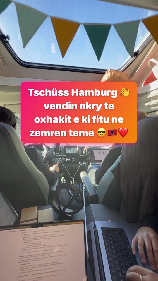 The inside of a camper with bunting, laptops and a bright farewell message to Hamburg over the original video.