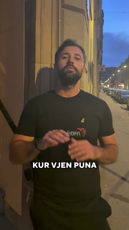 Eduard Luta discussing happiness and expectations beside a building on an evening street.