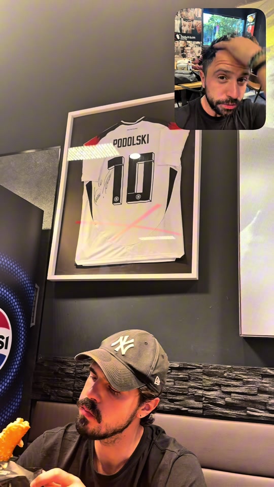 A framed Podolski number-ten shirt inside the Düsseldorf döner shop, with Eduard visible in the original video inset.