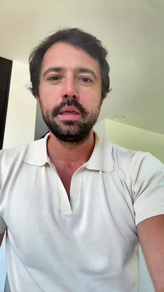 Eduard wearing a light polo shirt, speaking to the camera indoors.