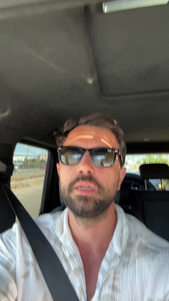 Eduard in a car wearing sunglasses in the original short video about roadworks.