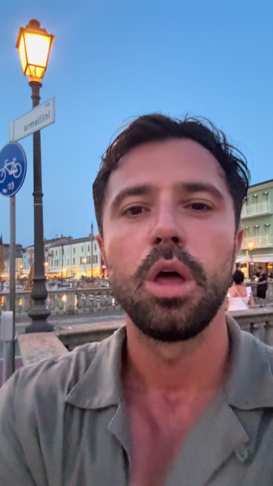 Eduard beside a waterfront at dusk in the original video about the last word and biceps.