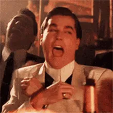 Man in a suit laughing heartily, the classic Goodfellas laughing meme