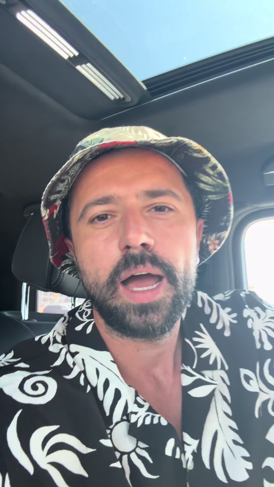 Eduard in a car wearing a bucket hat and patterned shirt, in the original video about enthusiasm.