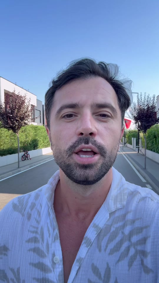 Eduard walking on a residential street under a blue sky in the original video about reincarnation.